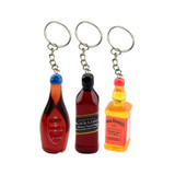 Three colourful resin keychains shaped like drink bottles, featuring red, amber, and black designs with keyring attachments.