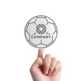 A hand holding a round promotional foam mitt designed to resemble a soccer ball, featuring a logo.