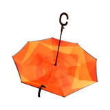 An orange reversible folding umbrella with a curved handle and a contrasting inner layer design.