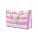 A pink and white striped beach bag with a rope handle and side pocket, featuring a logo.