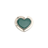 A heart-shaped, foldable desk hook with a silver frame and a teal interior, featuring small metallic fasteners.