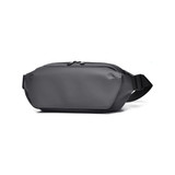 A grey fanny pack with a sleek design and adjustable strap, featuring a zippered compartment.