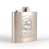 A stainless steel hip flask with an engraved eagle design, featuring a screw-top lid.
