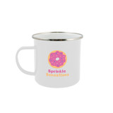 A white enamel mug featuring a colorful donut design and a logo. The mug has a shiny metal rim.
