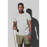 A man wearing a grey active t-shirt and olive green shorts, holding exercise resistance bands. The shirt has a logo.