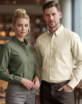 A men's smart casual long-sleeve shirt in cream, alongside a women's shirt in olive green, both with a logo.