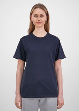 A women's short sleeve tee in navy blue with a relaxed fit, paired with light grey pants. The tee has a logo.