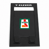 A black foldable phone stand featuring a logo on the front. The design is sleek and minimalist.