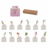 A floral-themed desk calendar featuring twelve illustrated monthly pages, displayed with a wooden holder.