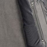 A close-up of a women's softshell jacket in black and grey, featuring a zippered pocket.