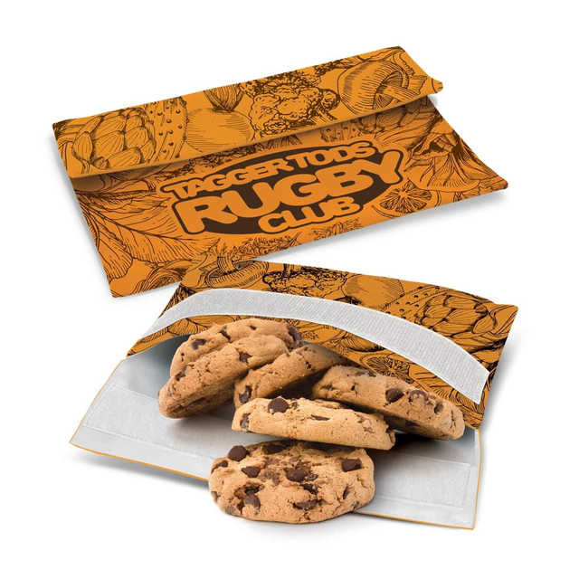An orange reusable snack pouch with a floral design, containing chocolate chip cookies inside.