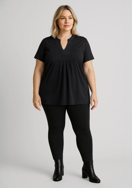 Women’s high-rise black leggings paired with a black top, featuring a V-neck and short sleeves. The model is wearing ankle boots.