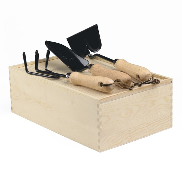 A wooden garden box containing three gardening tools with wooden handles and metal heads.