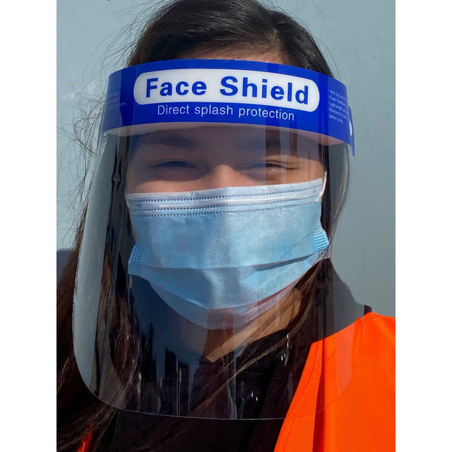 A full-length face shield with a blue top and transparent visor, worn by a person in a face mask and orange vest. A full-length face shield with a blue top and transparent visor, worn by a person in a face mask and orange vest.