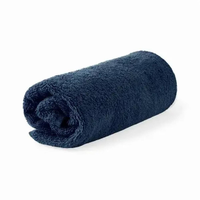 A rolled organic cotton bath towel in navy blue, featuring a simple design and a branding logo.