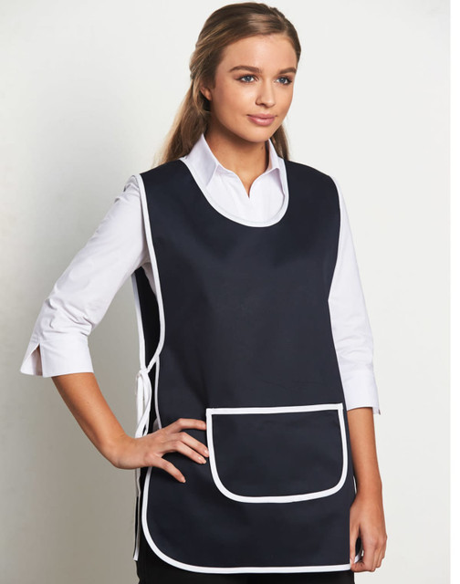 A navy blue ladies' smock apron with white trim and a front pocket, featuring a model wearing it. A navy blue ladies' smock apron with white trim and a front pocket, featuring a model wearing it.