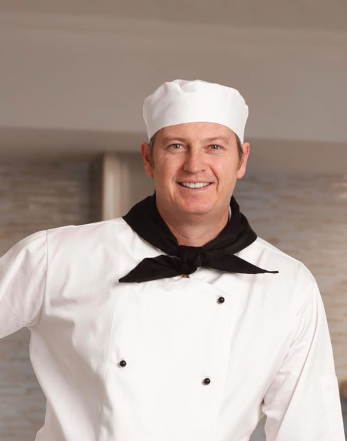 A chef wearing a white uniform and a black scarf, smiling against a light background. The image includes a chef's hat.