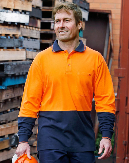 A long-sleeved safety polo in orange and navy, featuring a logo, worn by a man outdoors near wooden pallets. A long-sleeved safety polo in orange and navy, featuring a logo, worn by a man outdoors near wooden pallets.