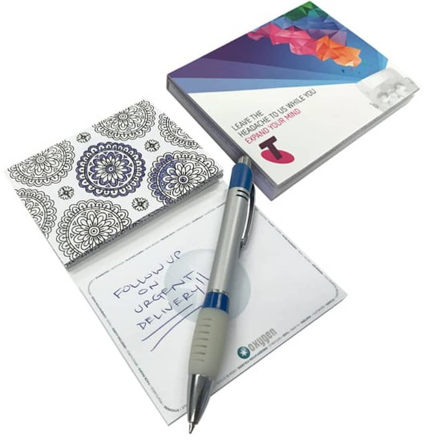 A patterned notepad and a pen on a white background, featuring a branded cover. The notepad has blank pages.