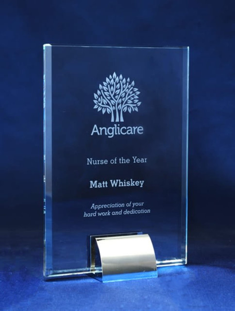 A glass award with an engraved design and text, featuring a silver stand, set against a blue background. A glass award with an engraved design and text, featuring a silver stand, set against a blue background.