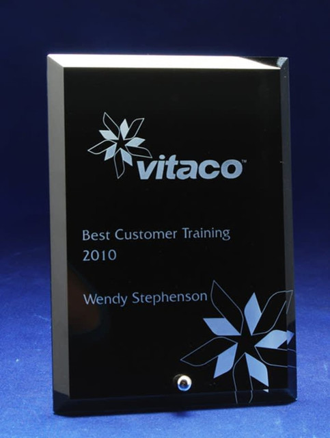 A rectangular black glass award with a floral design and a silver accent, featuring laser-engraved text. A rectangular black glass award with a floral design and a silver accent, featuring laser-engraved text.