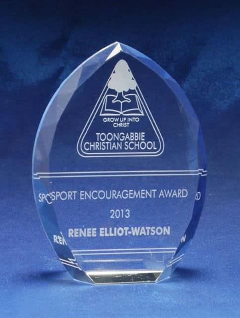 A crystal award with a teardrop shape, featuring engraved text and a logo, displayed on a blue fabric background. A crystal award with a teardrop shape, featuring engraved text and a logo, displayed on a blue fabric background.
