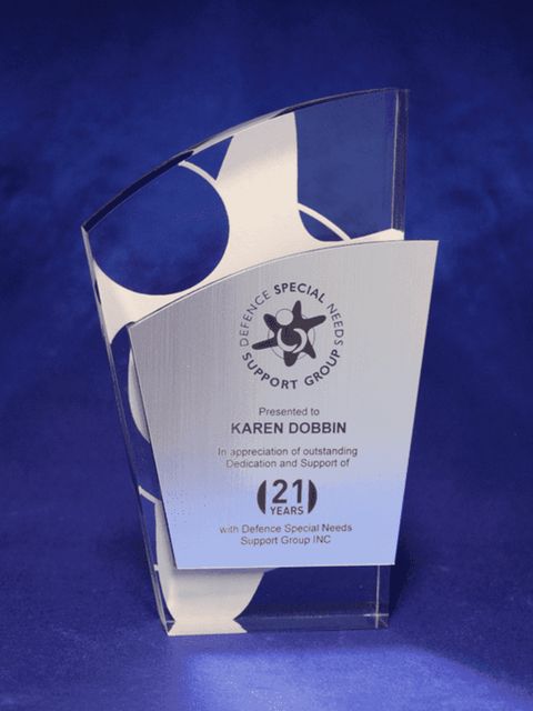 A contemporary acrylic trophy featuring a metalex facia with laser engraving, displaying a sleek design in clear and silver.