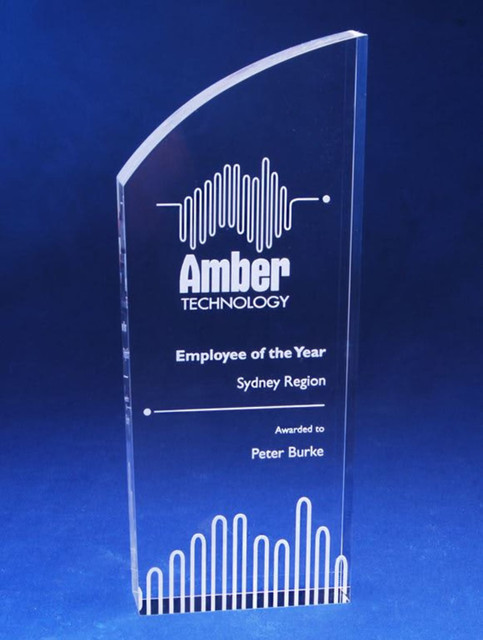 A clear acrylic trophy with a curved top and laser engraving, featuring a logo and text for "Employee of the Year". A clear acrylic trophy with a curved top and laser engraving, featuring a logo and text for "Employee of the Year".