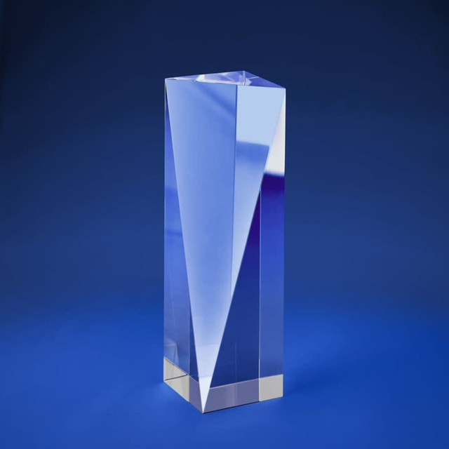 A tall, clear optical crystal award with a V-shaped design, set against a blue background. A tall, clear optical crystal award with a V-shaped design, set against a blue background.