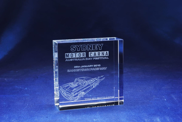 A square optical crystal award featuring etching of a car, with a clear finish set against a deep blue background. A square optical crystal award featuring etching of a car, with a clear finish set against a deep blue background.