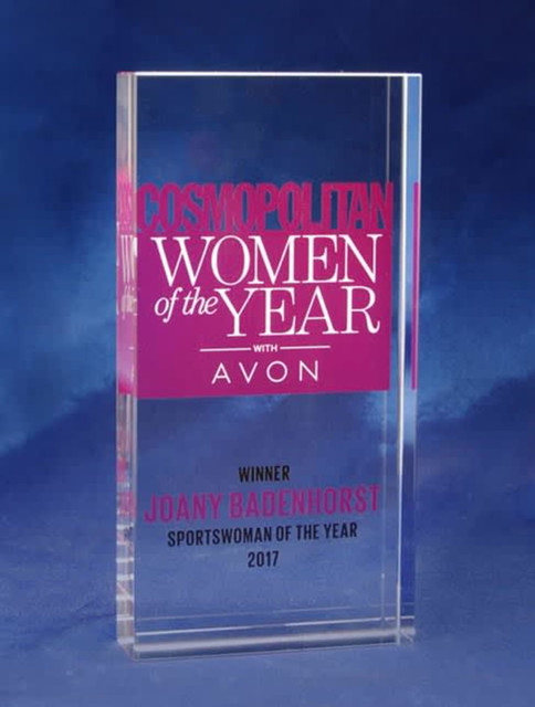 A clear optical crystal award with a vibrant pink printed background featuring text for "Women of the Year". A clear optical crystal award with a vibrant pink printed background featuring text for "Women of the Year".