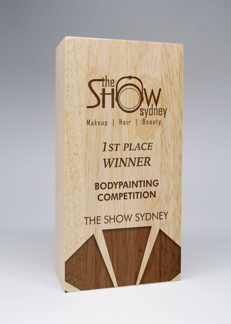 A wooden award with a natural finish, featuring engraved text about a bodypainting competition. A wooden award with a natural finish, featuring engraved text about a bodypainting competition.