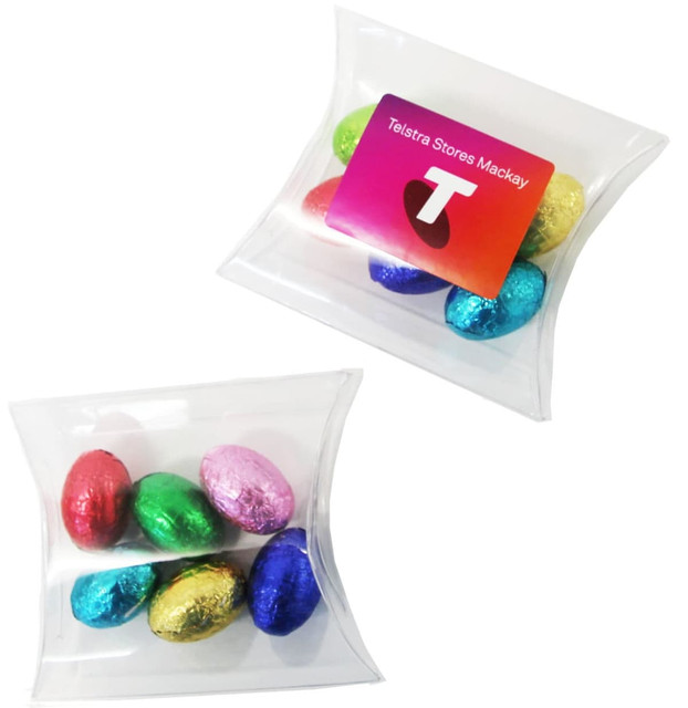 A clear pillow pack containing six mini solid chocolate Easter eggs in assorted colours: red, green, blue, gold, and silver. A clear pillow pack containing six mini solid chocolate Easter eggs in assorted colours: red, green, blue, gold, and silver.