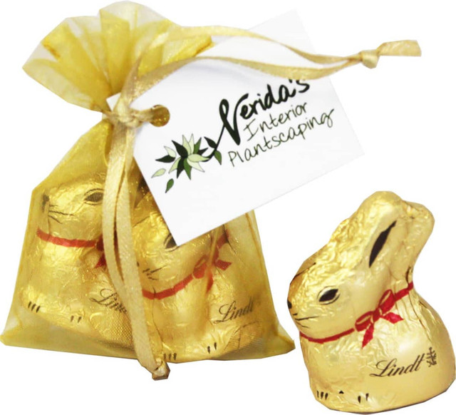 A gold organza bag containing two 10g Lindt chocolate bunnies, tied with ribbon and a branded tag. A gold organza bag containing two 10g Lindt chocolate bunnies, tied with ribbon and a branded tag.