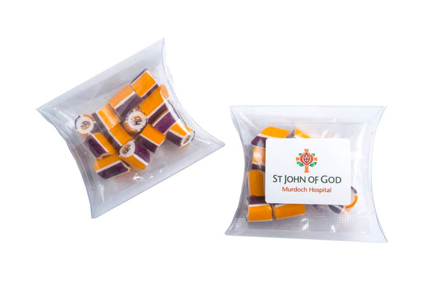 A clear pillow pack containing assorted rock candy pieces in purple and orange, with a logo on the packaging. A clear pillow pack containing assorted rock candy pieces in purple and orange, with a logo on the packaging.
