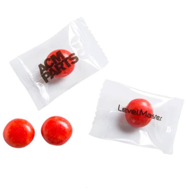 Individually wrapped red chewy sweets are displayed, with one wrapper visible showing a logo. Individually wrapped red chewy sweets are displayed, with one wrapper visible showing a logo.