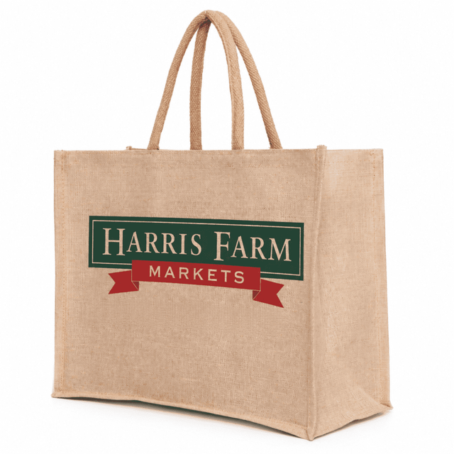 A large, natural-coloured juco bag with sturdy handles and a logo on one side.