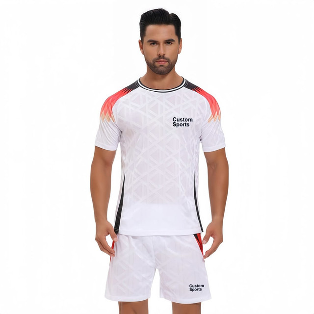 A crew neck raglan tee shirt in white with red and black accents, featuring a logo on the front, paired with matching shorts.