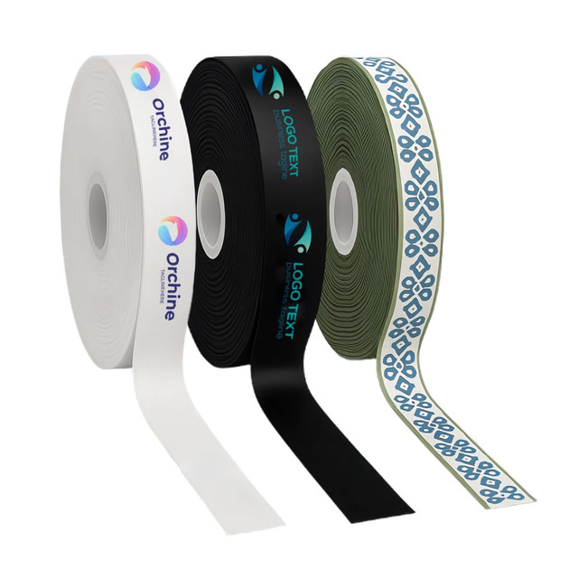Three rolls of satin polyester ribbon in white, black, and olive green, featuring various designs and logos.