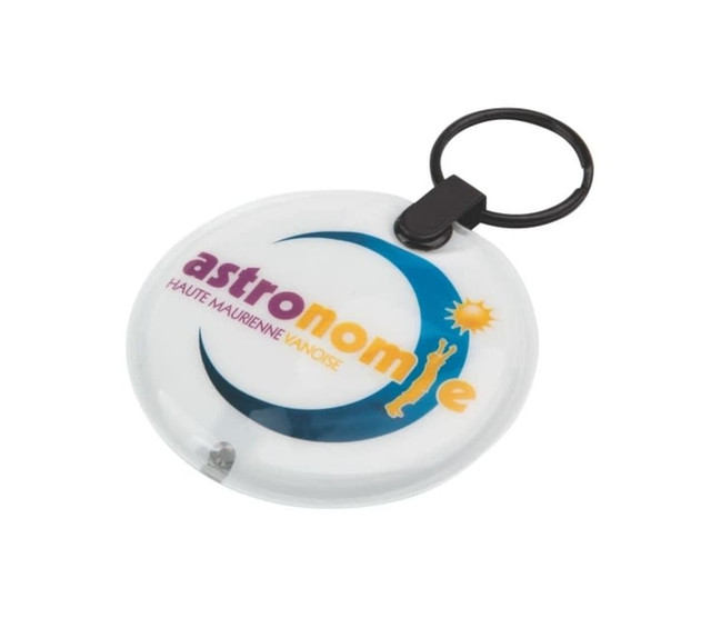 A circular white keyring with a black keychain attachment, featuring a logo that includes blue and yellow elements.
