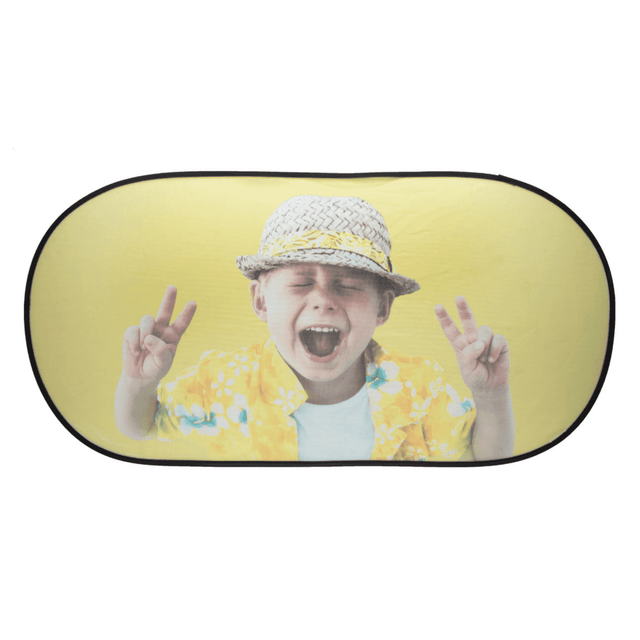 A folding car sunshade featuring a cheerful child in a yellow floral shirt and hat, with a playful peace sign gesture.