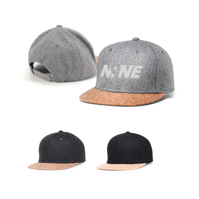 A flat cork snapback cap with a grey body, a cork brim, and additional black and dark grey variations.