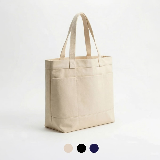 A cream tote bag featuring three pockets and two sturdy handles, with options in black and navy.