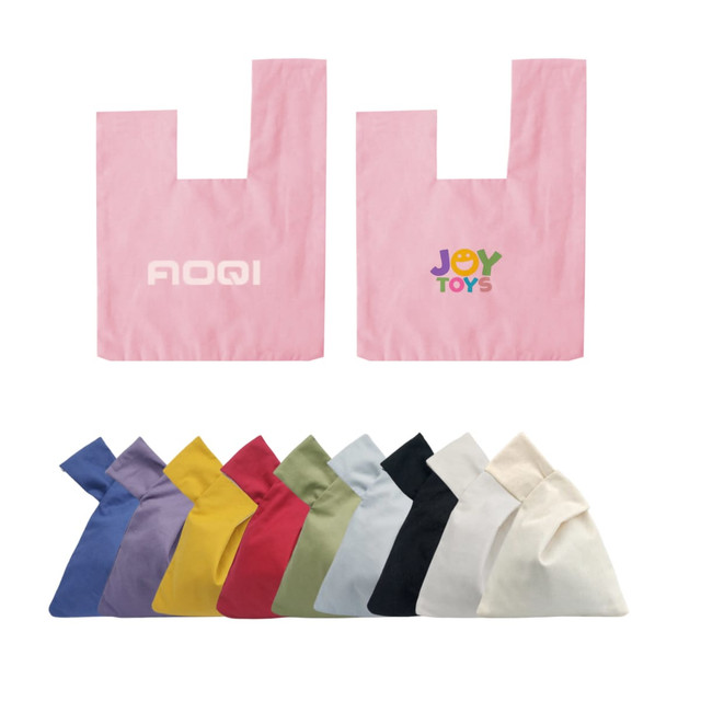 A cotton wrist bag in pink with a logo, alongside bags in various colours including yellow, green, purple, and blue.