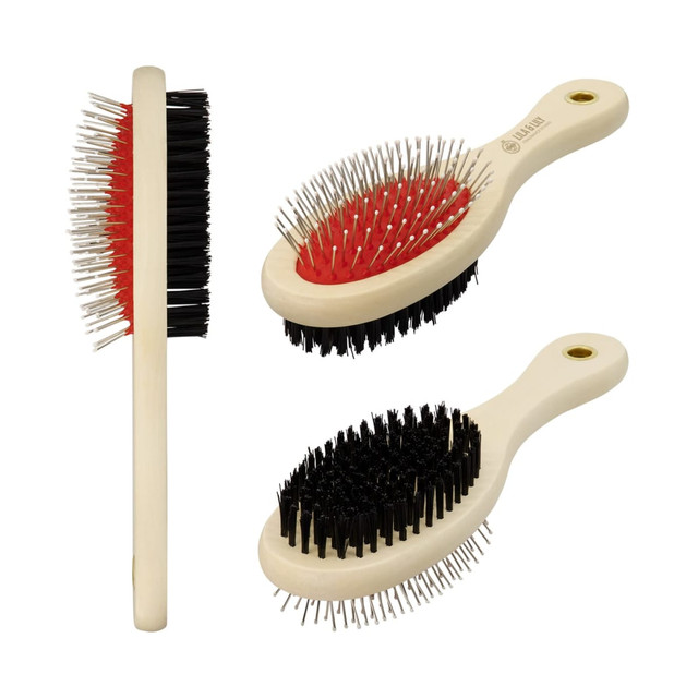 A pet grooming brush with a cream handle, featuring red and black bristles. The brush has a rounded design and logo.
