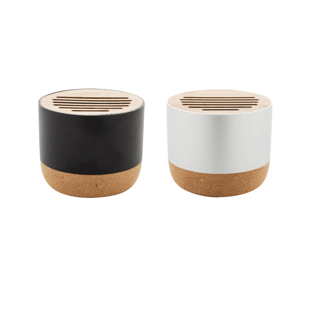 Two wireless speakers in black and white, featuring a cork base and a slotted wooden top, each with a logo.