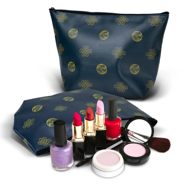 A medium navy cosmetic bag with a logo pattern, accompanied by various lipsticks, nail polishes, and cosmetic brushes.