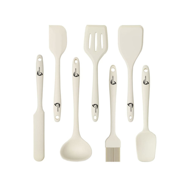 A silicone kitchenware set in cream colour includes a spatula, ladle, slotted spatula, basting brush, and other utensils.