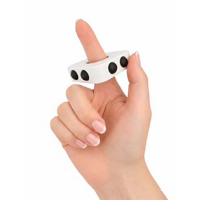A white finger spinner held between fingers, featuring three black buttons on its surface.