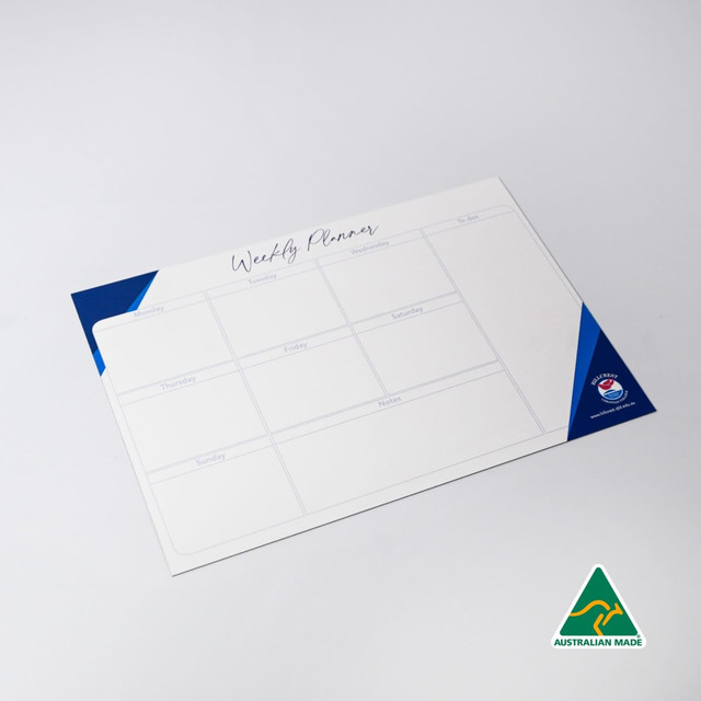 A magnetic whiteboard in white and blue, featuring a weekly planner layout with multiple sections.